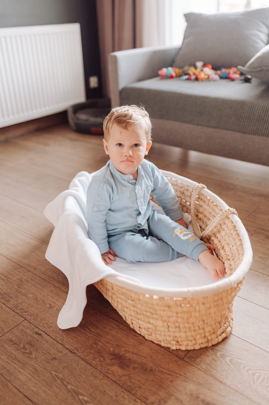 Starszy chłopiec w koszu Mojżesza sesja rodzinna w domu