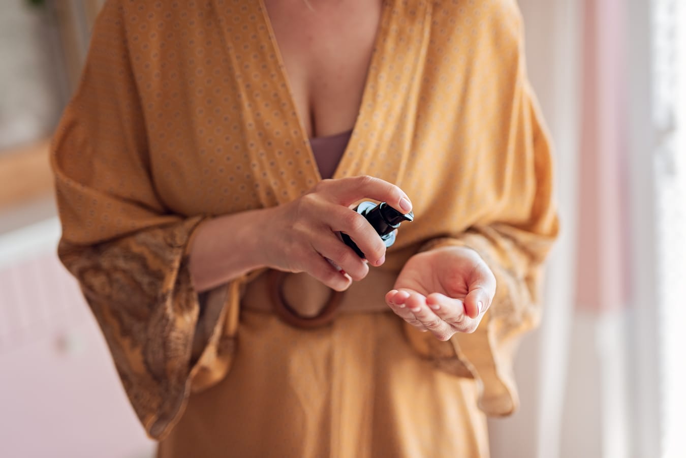 Ręce terapeutki delikatnie mieszają olejki, tworząc aromatyczną kompozycję.