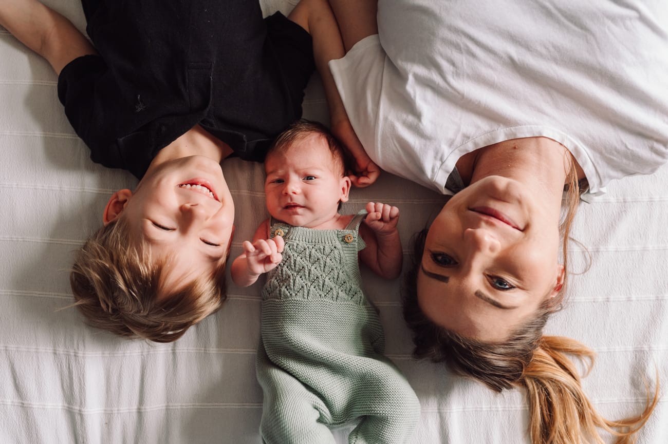 Mama z noworodkiem i starszym synem domowa sesja
