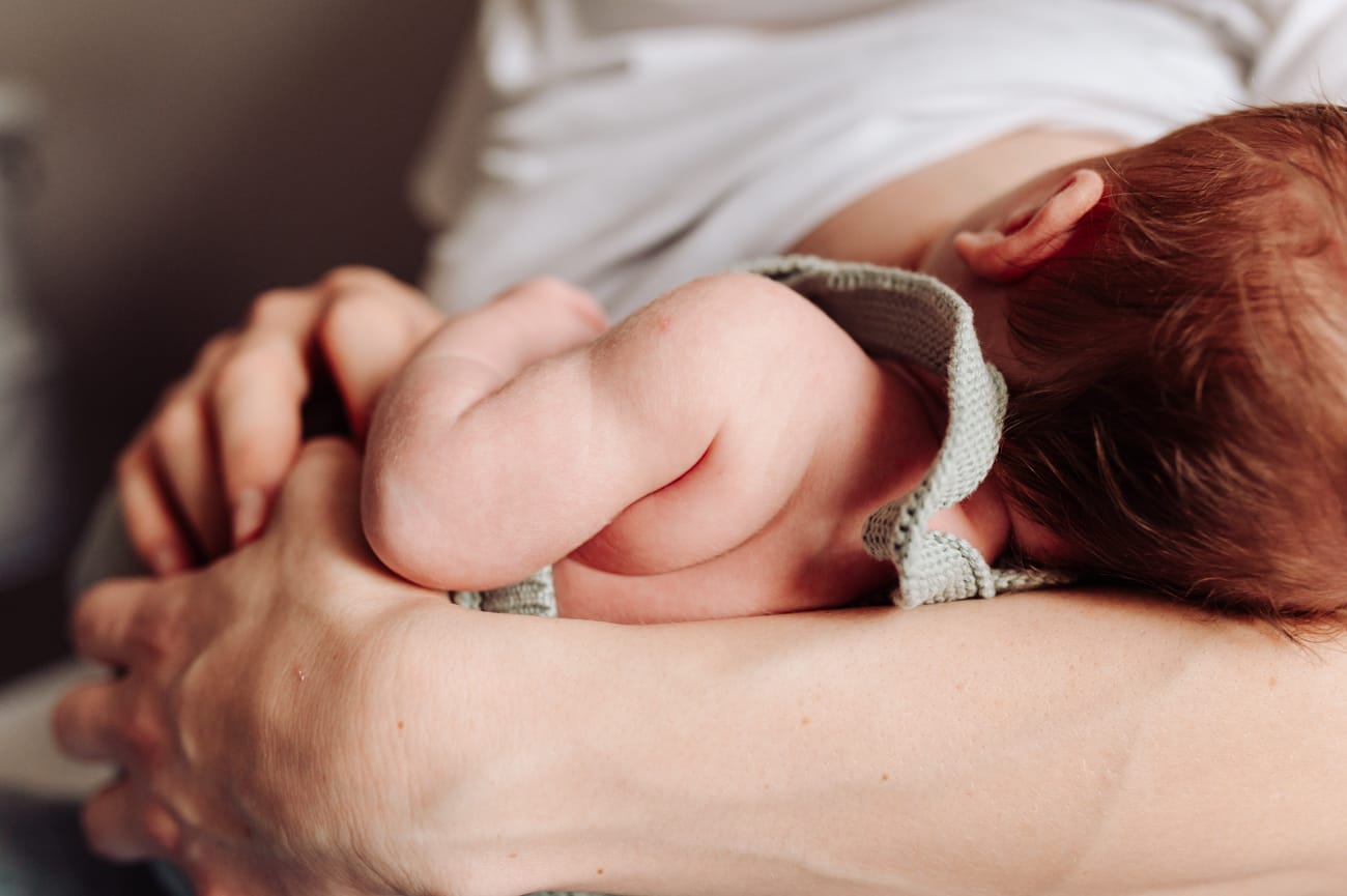 Noworodek przy piersi mamy sesja noworodkowa w domu