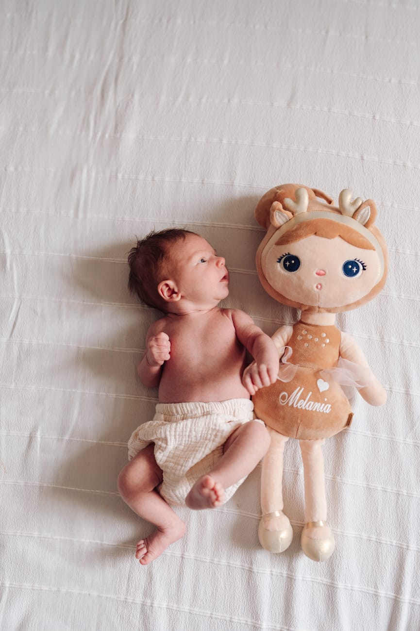 Noworodek obok lalki porównanie wielkości sesja w domu

