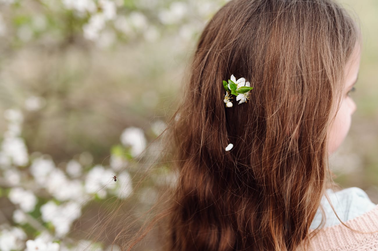 Kwiatki we włosach dziewczynki sesja dziecięca wiosna