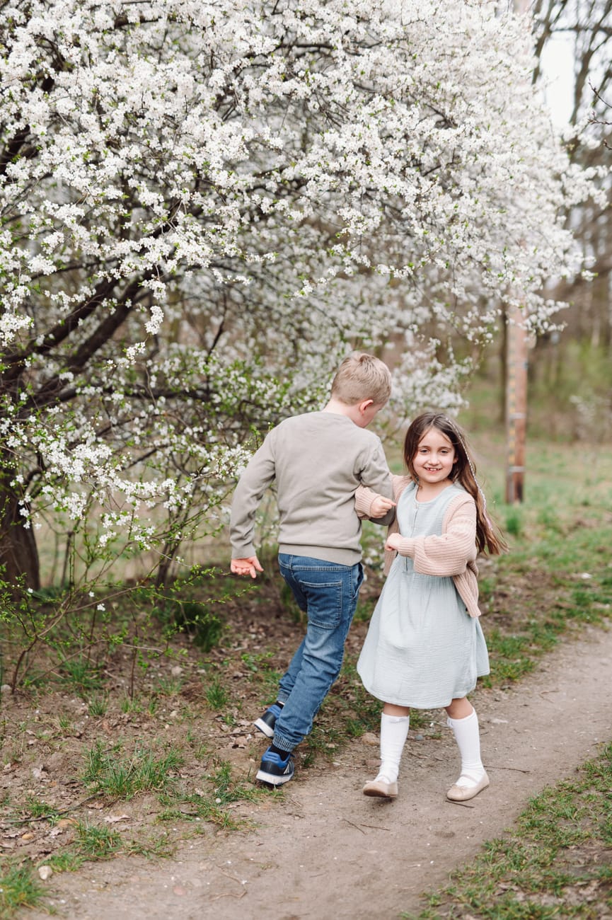 Dzieci tańczą wśród kwitnących drzew sesja Gdynia