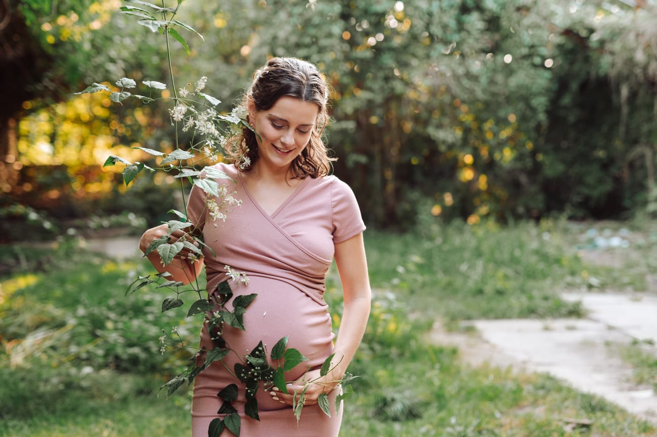 Pnącza okalające brzuszek ciążowy sesja w plenerze