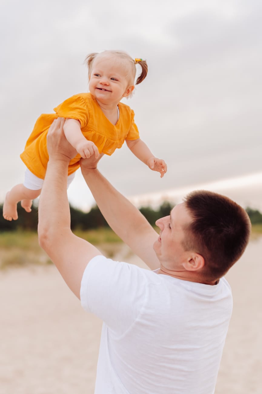 Tata podrzuca niemowlaka sesja rodzinna w wakacje