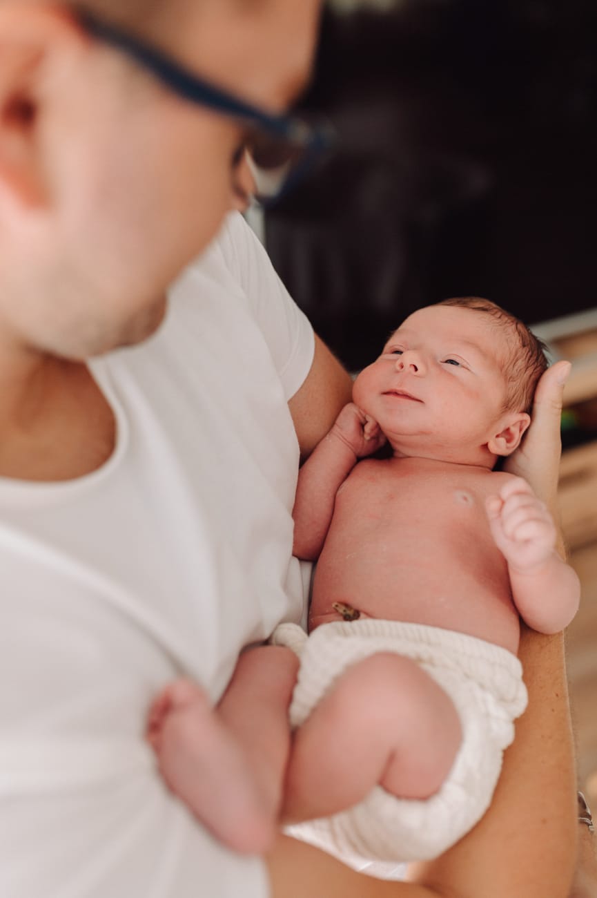 Noworodek w ramionach taty sesja noworodkowa Gdynia