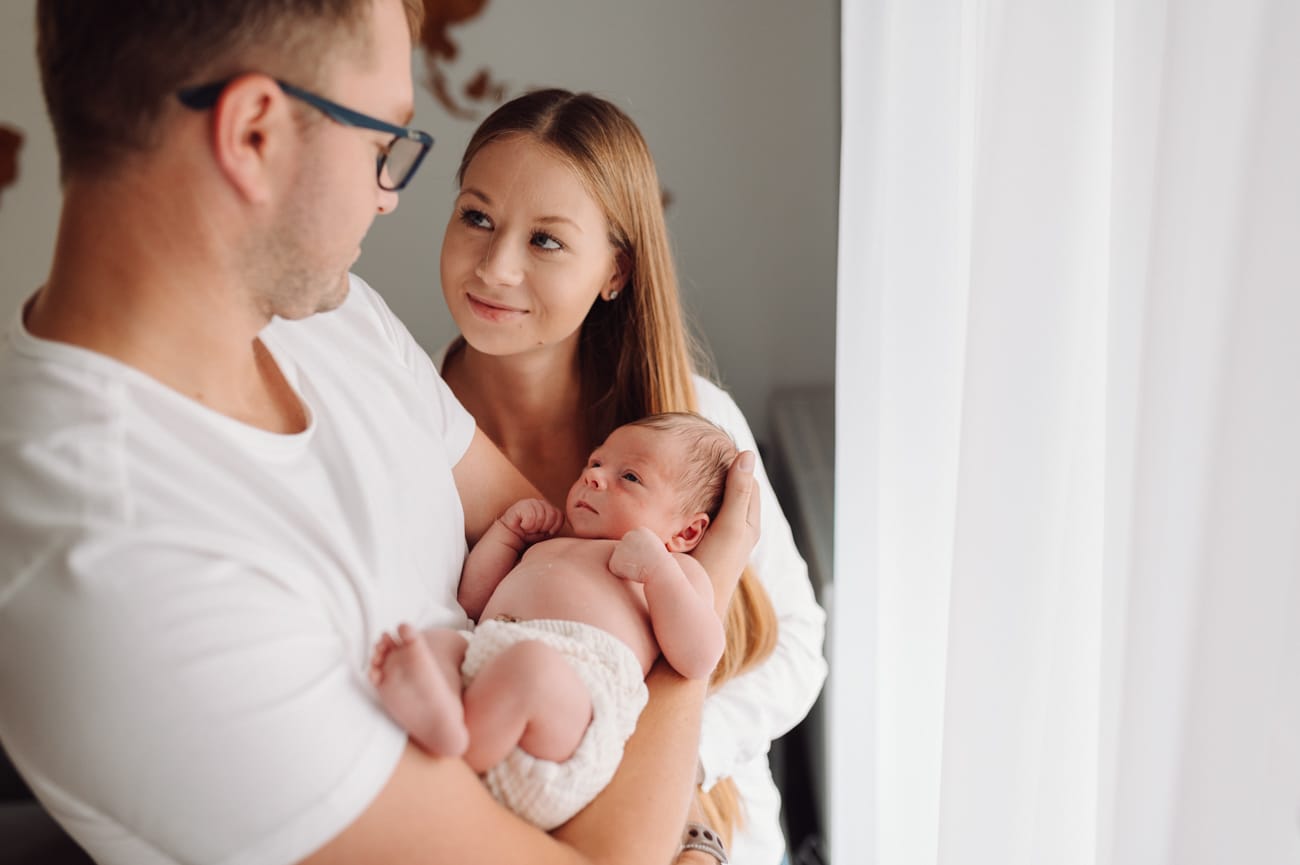 Rodzice trzymają noworodka sesja lifestyle w domu Gdynia