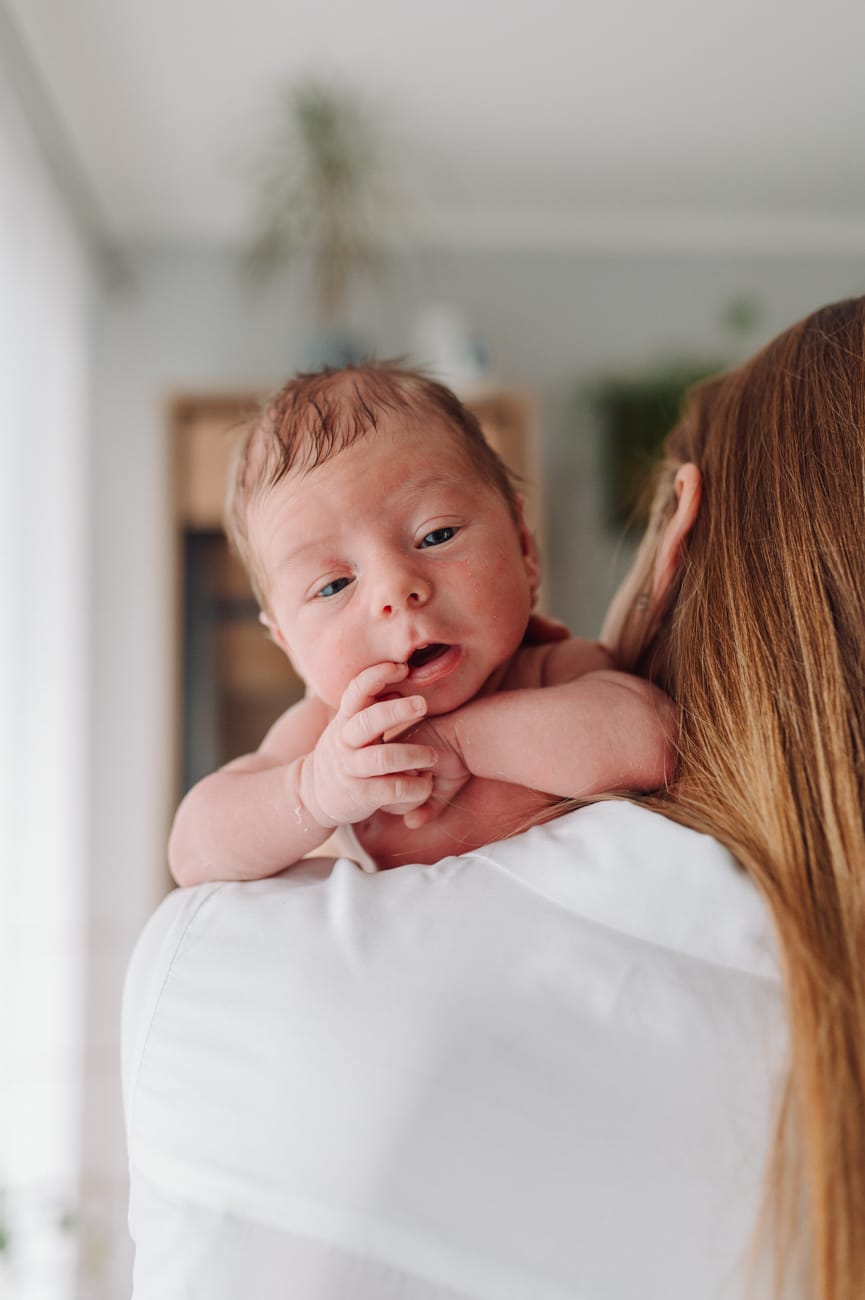 Noworodek leżący na ramieniu mamy - domowa sesja noworodkowa lifestyle Trójmiasto.