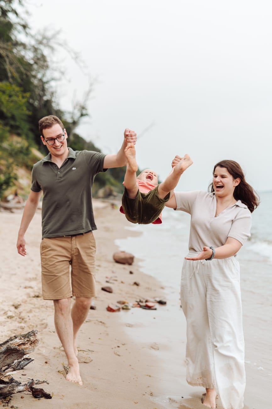 Rodzice huśtają dwulatka nad morzem sesja Gdynia