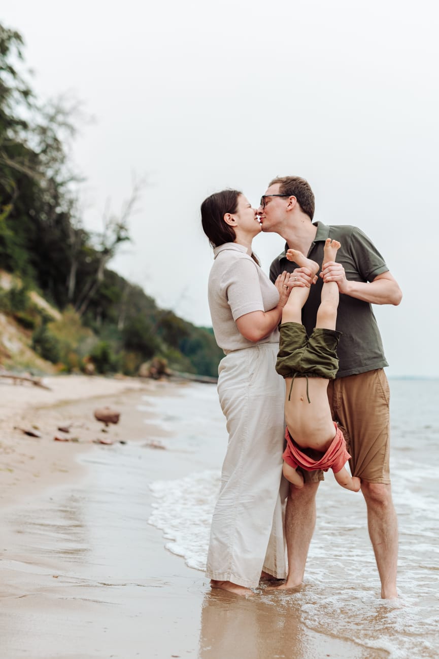 Rodzice bawią się z dwulatkiem na plaży sesja Gdynia