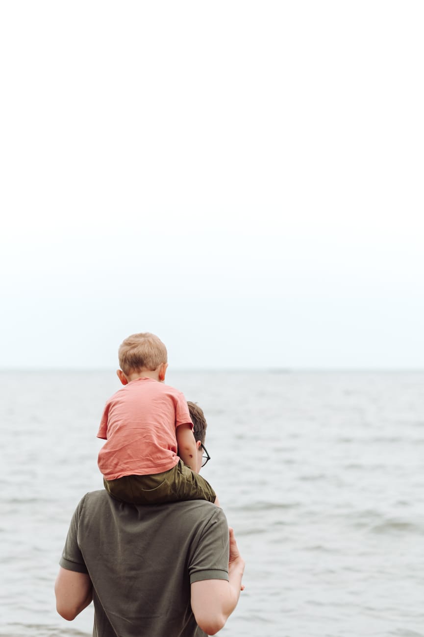 Tata z synem patrzą na burzowe chmury nad morzem