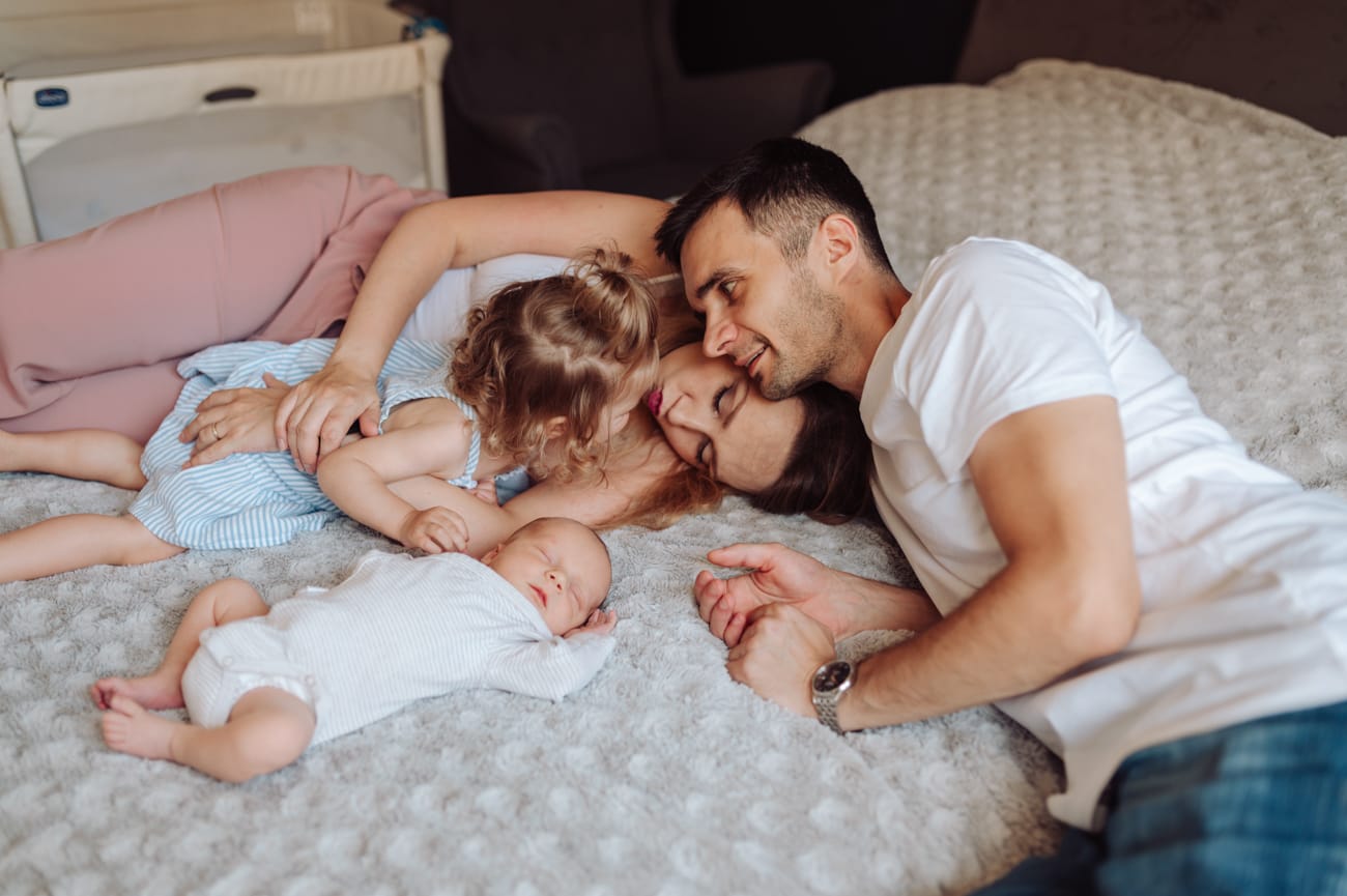 Rodzina na łóżku sesja noworodkowa z rodzeństwem Gdańsk