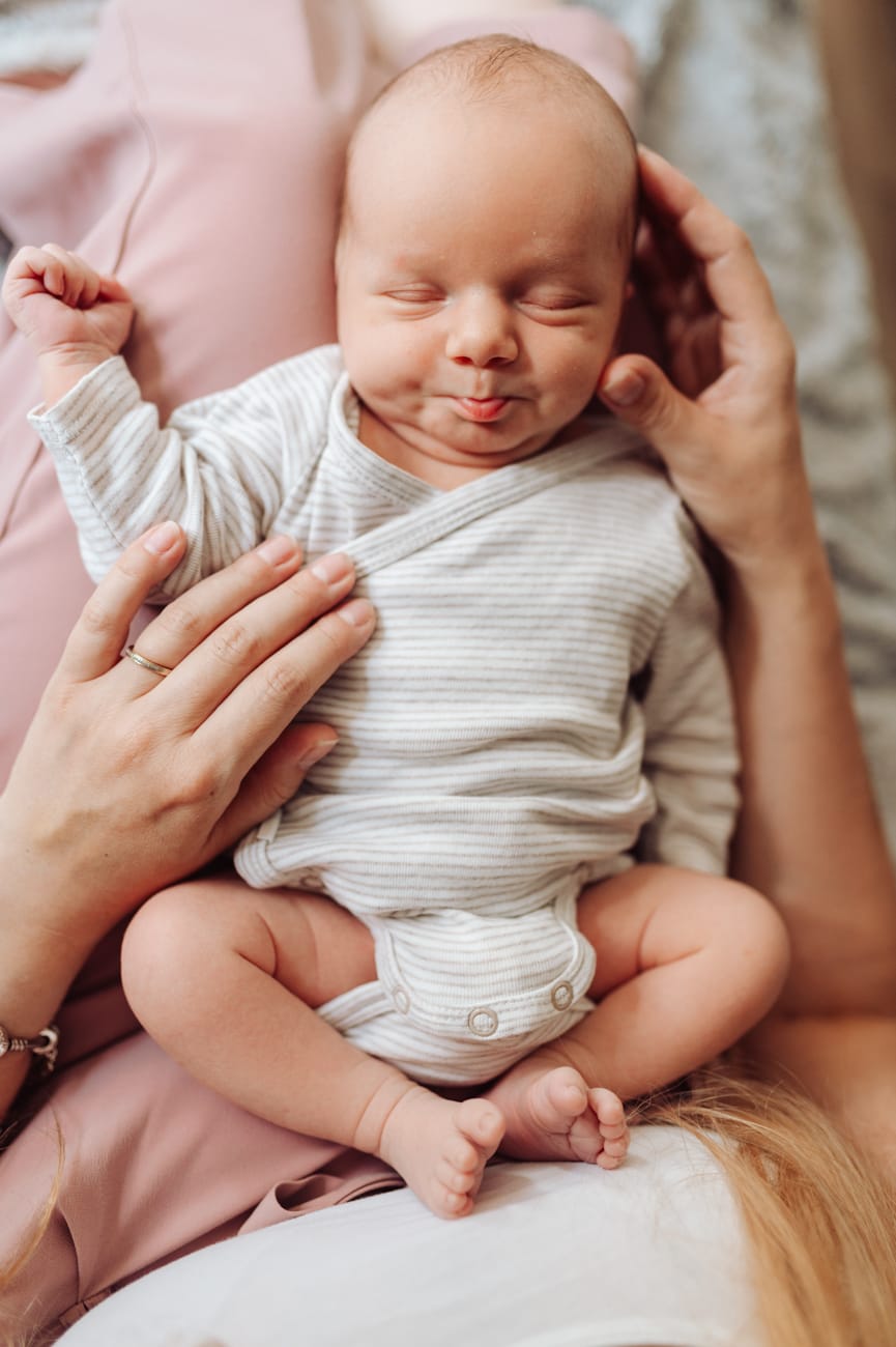 Noworodek na kolanach mamy pierwsze dni po porodzie
