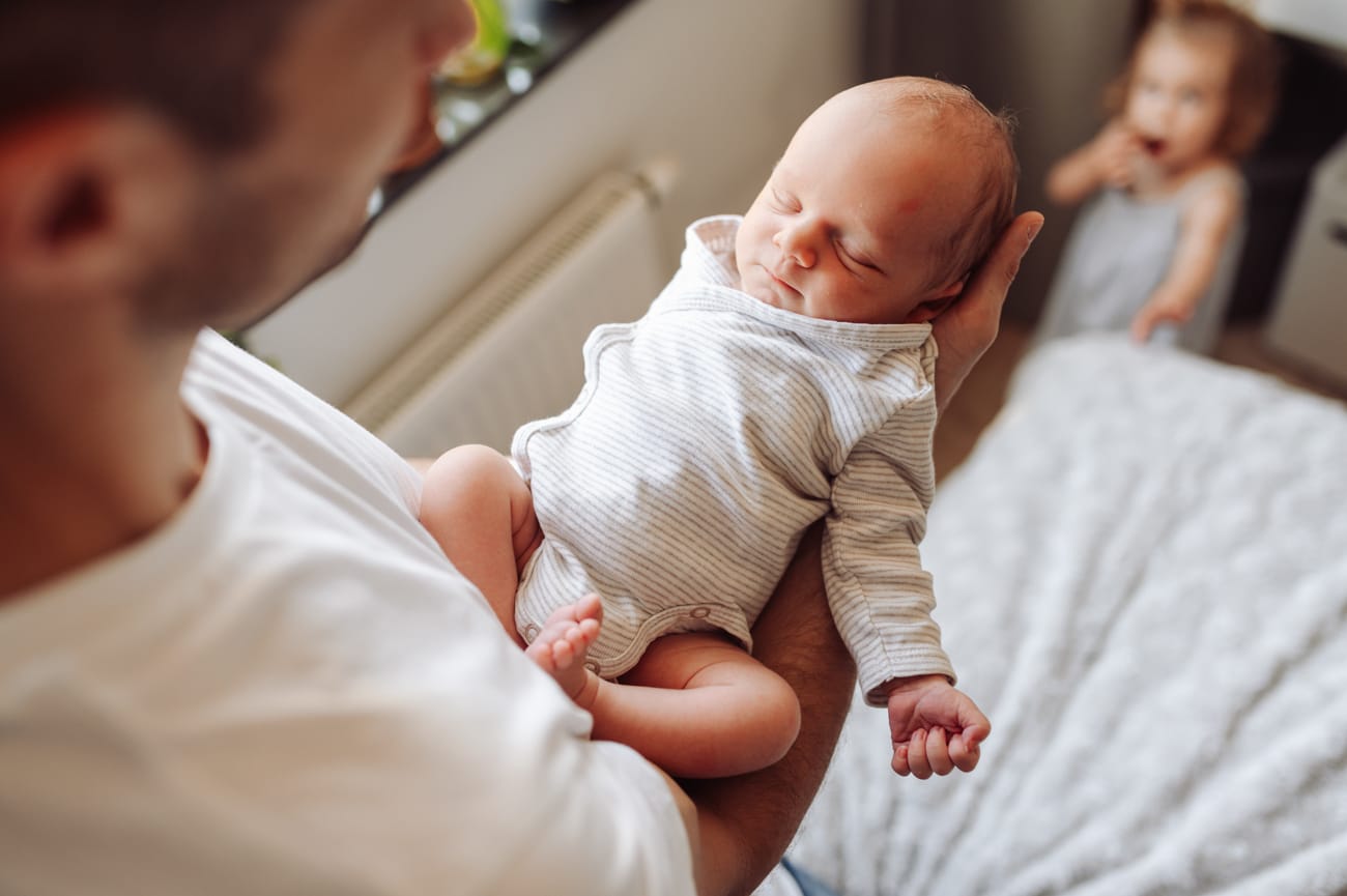 Tata z noworodkiem i siostra w tle sesja z rodzeństwem Gdańsk