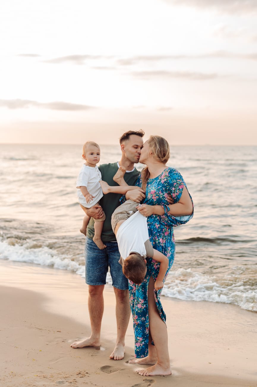 Rodzice całują się syn ucieka sesja rodzinna plaża