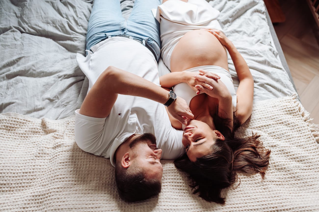 Para w sypialni naturalne światło sesja ciążowa