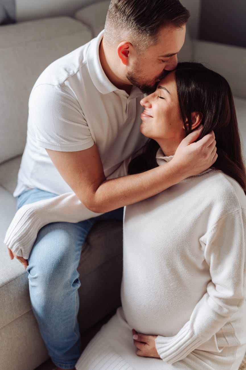 Mama w ciąży przytulana przez partnera w domu Gdynia
