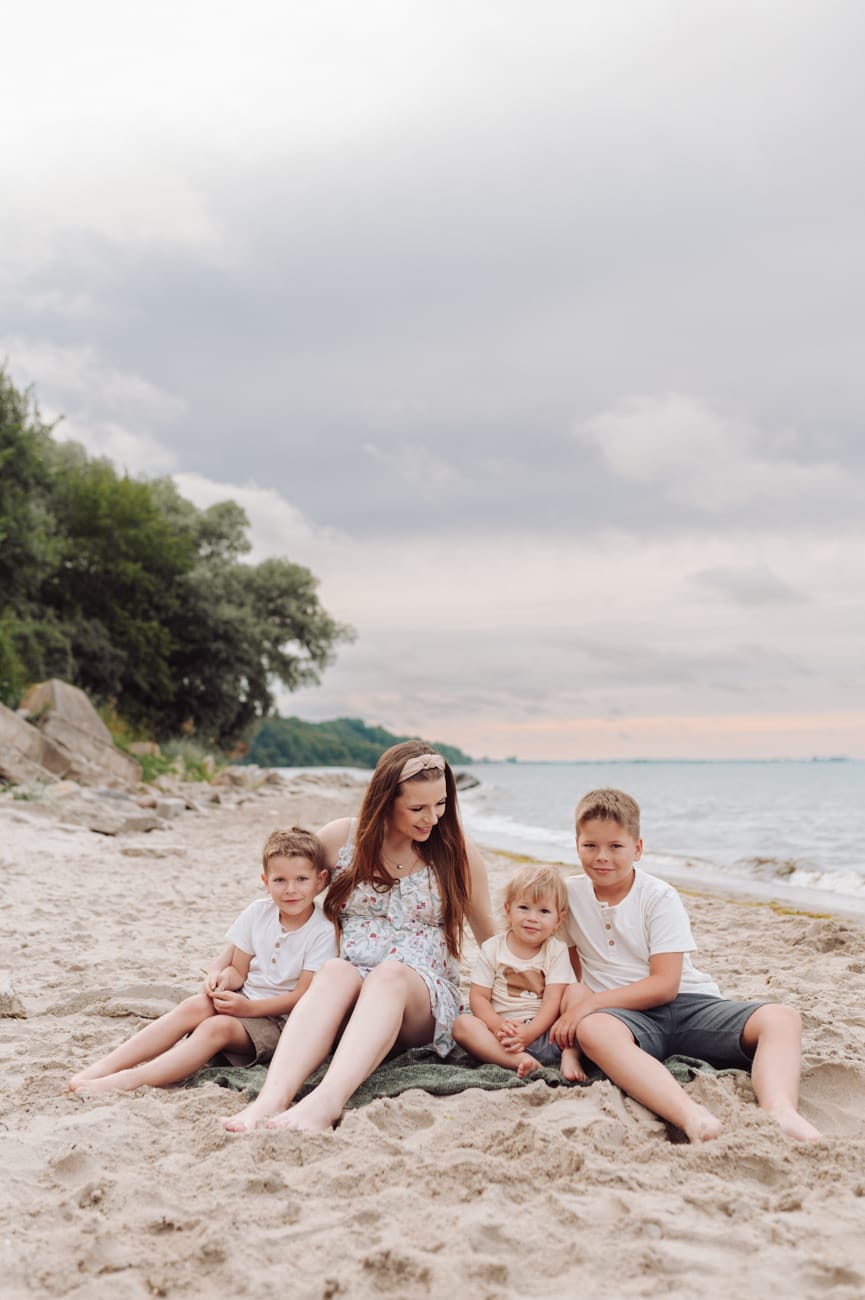 Mama w ciąży z synami na plaży wietrzny wieczór Gdynia