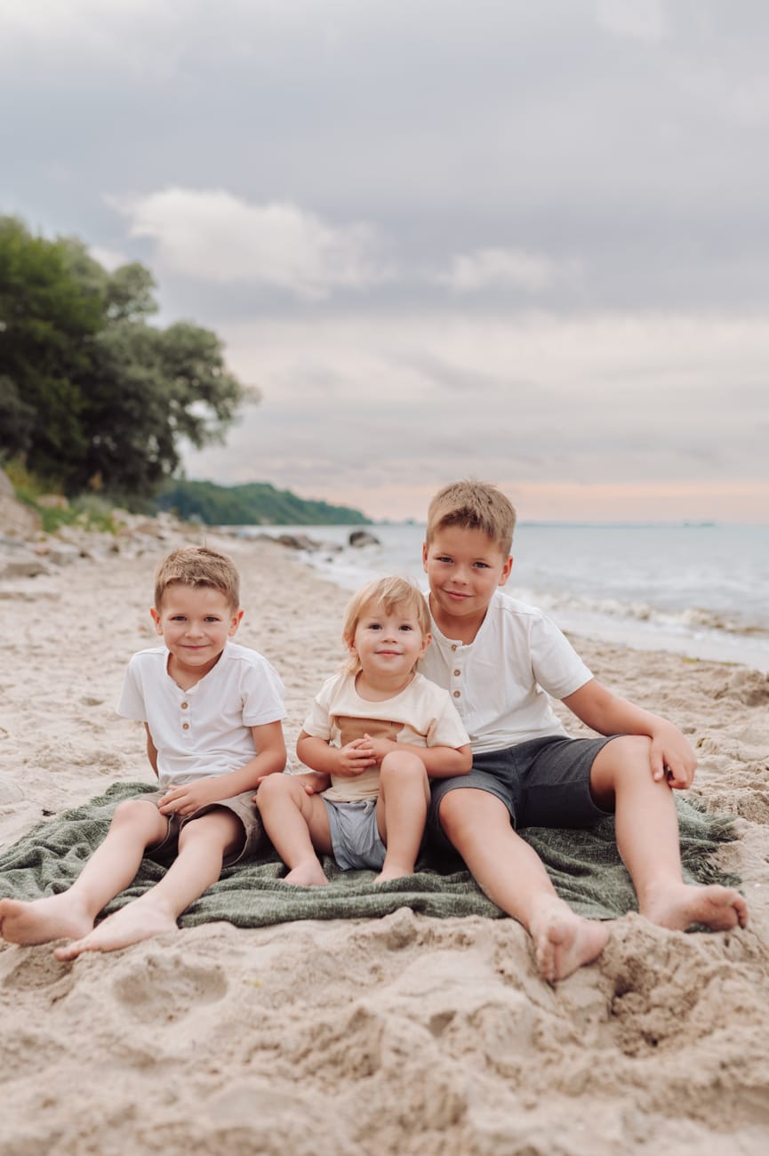 Dzieci śmieją się na plaży sesja ciążowa nad morzem