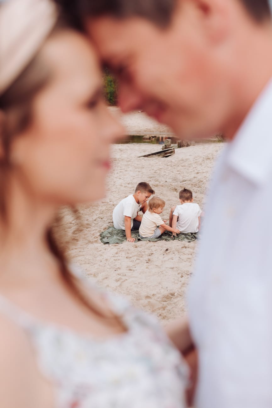 Rodzice przytuleni na plaży sesja ciążowa Gdynia