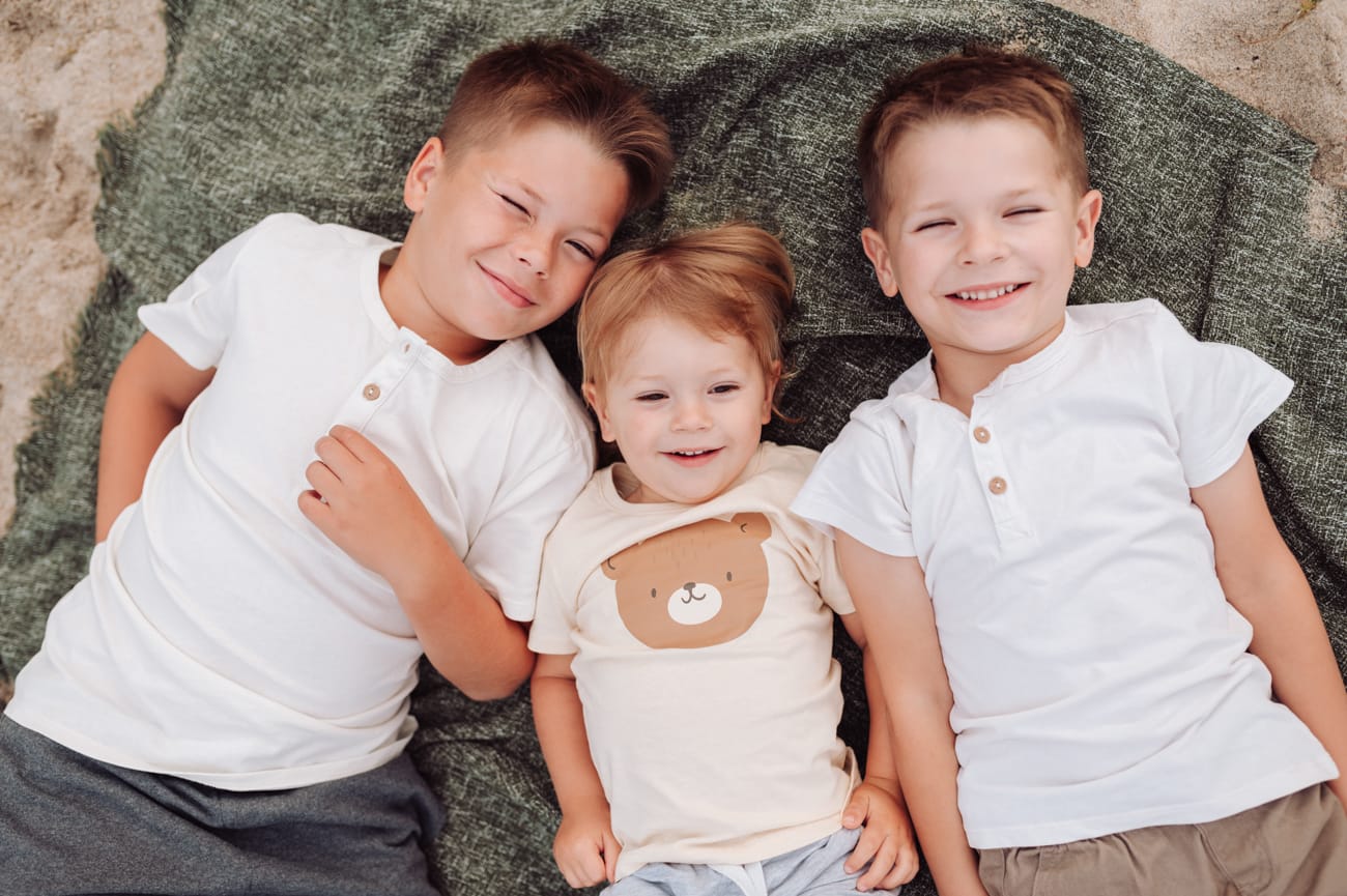 Trzej bracia na plaży radosny moment sesja Gdynia