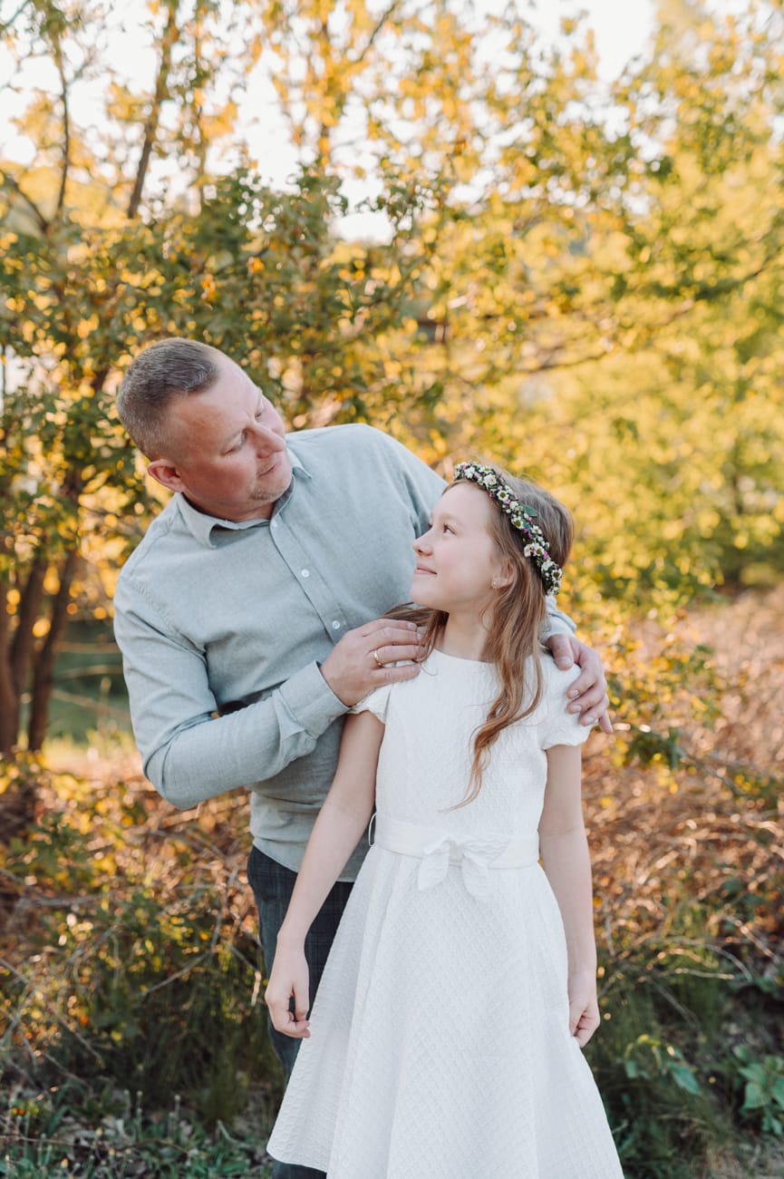 Tata patrzy na córkę po komunii plener komunijny