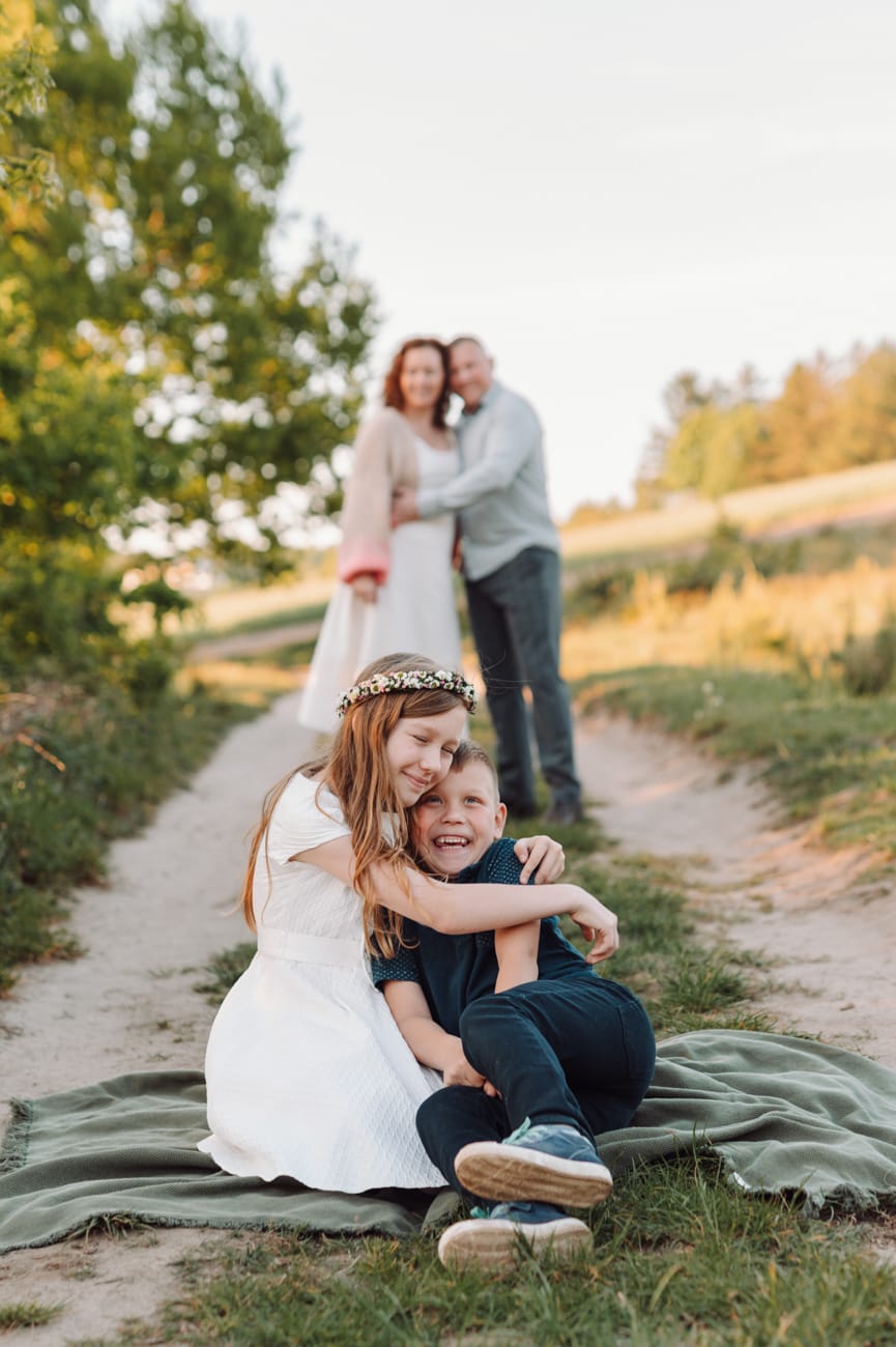 Dzieci na kocu rodzice w tle plener komunijny