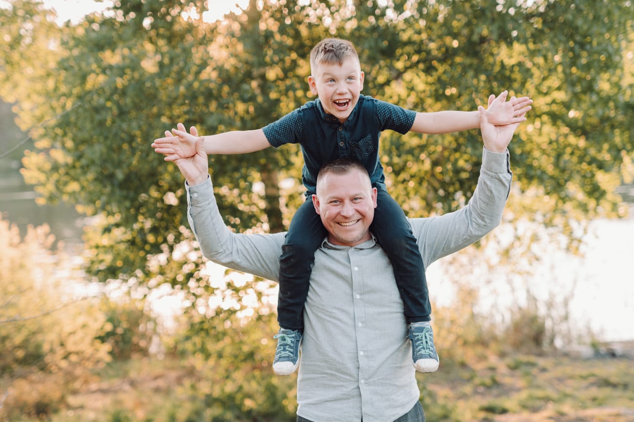 Tata niesie syna na barana plener komunijny
