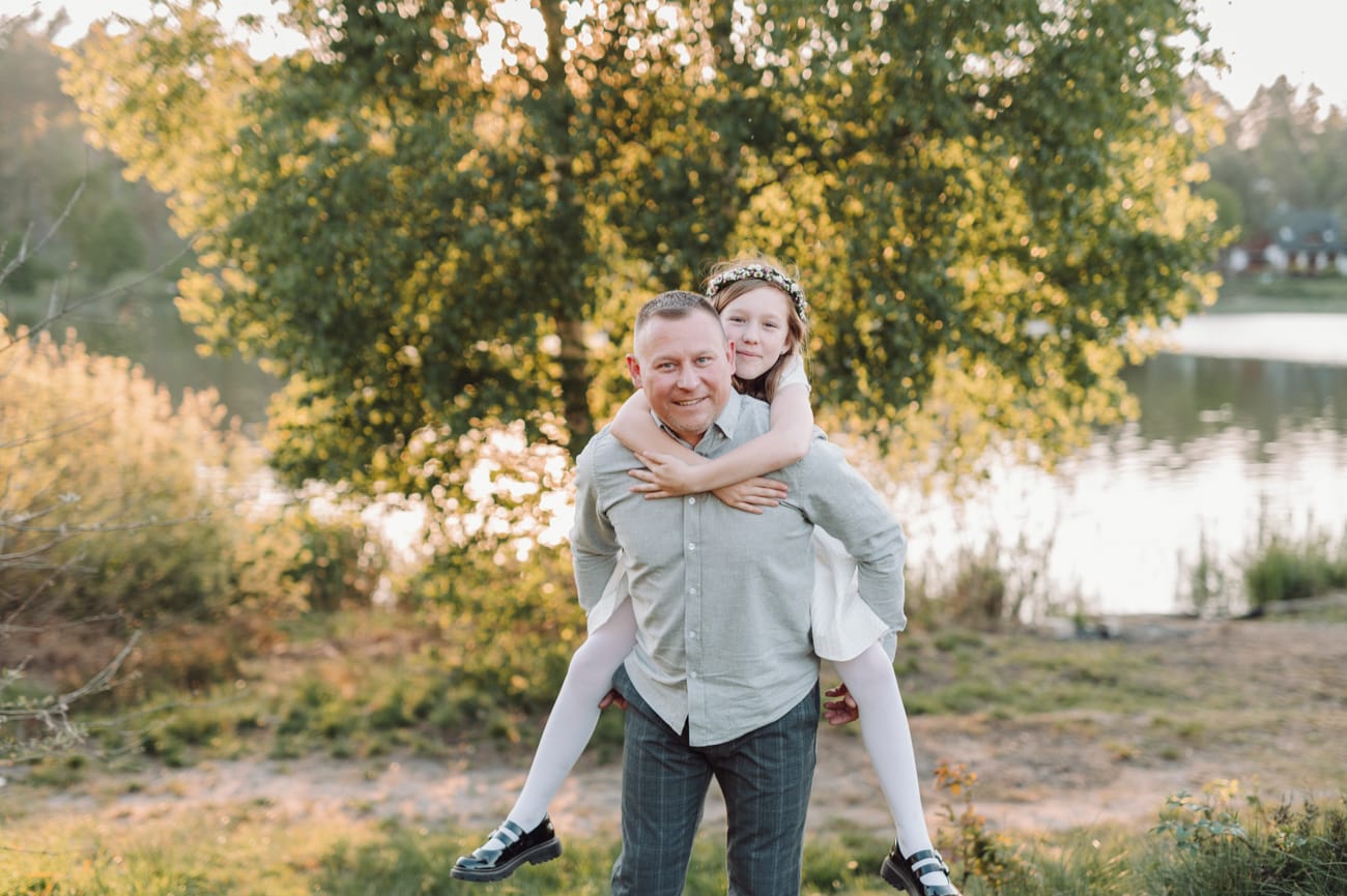 Tata trzyma córkę plener komunijny zachód słońca