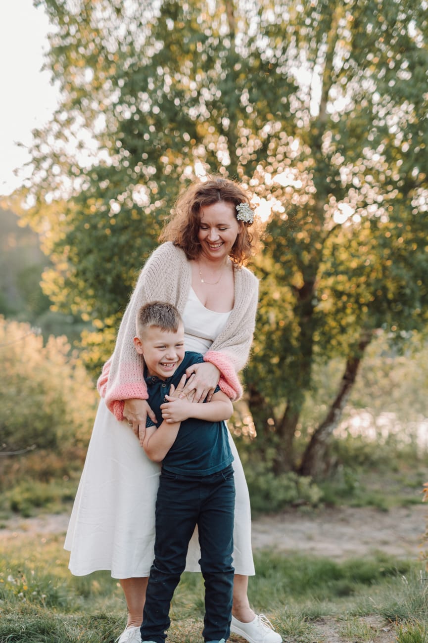 Mama przytula syna zachód słońca plener komunijny