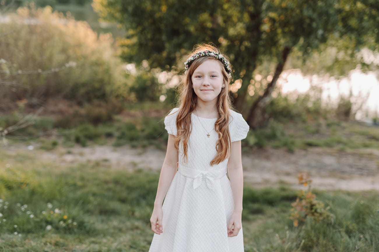 Portret dziewczynki komunijnej nad jeziorem zachód słońca