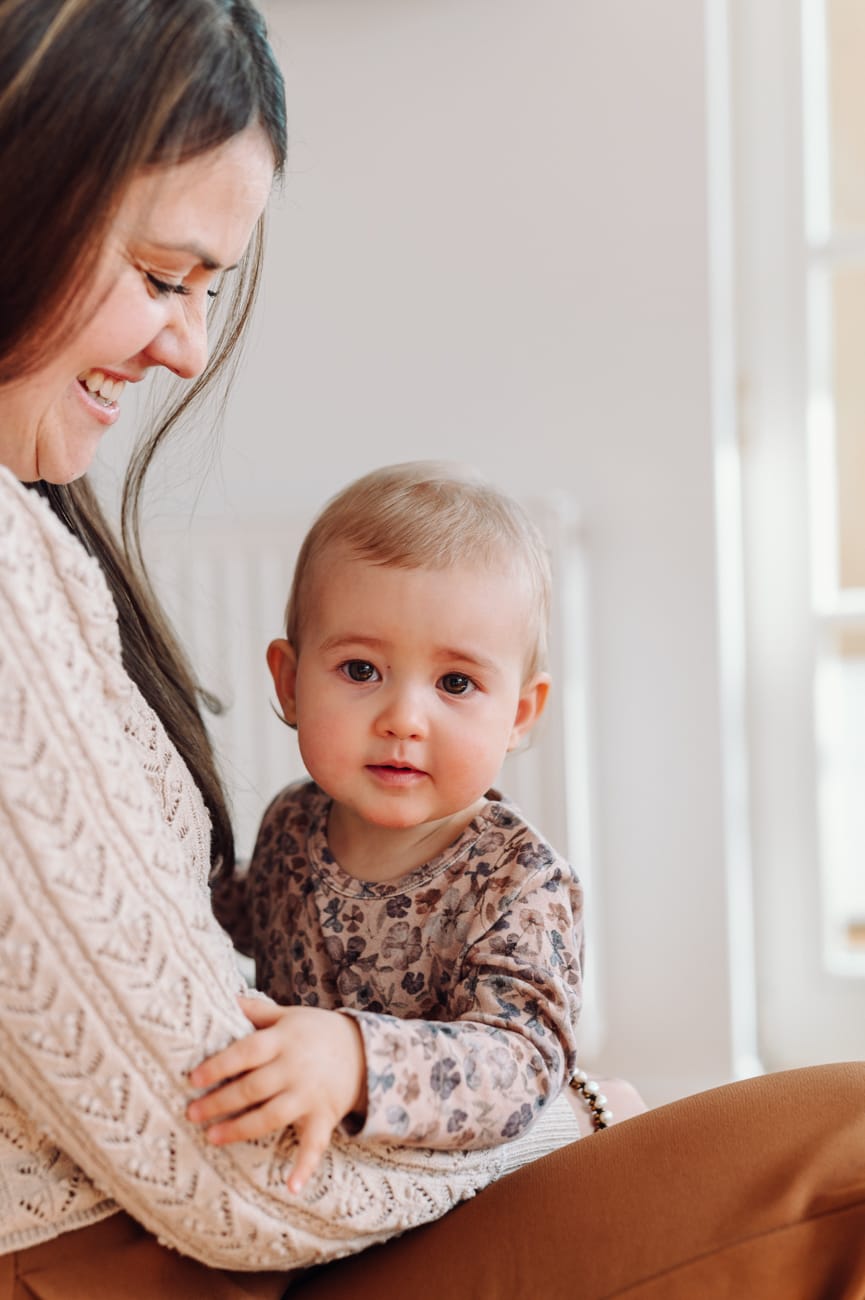 Dziewczynka zerka na fotografa sesja rodzinna w domu