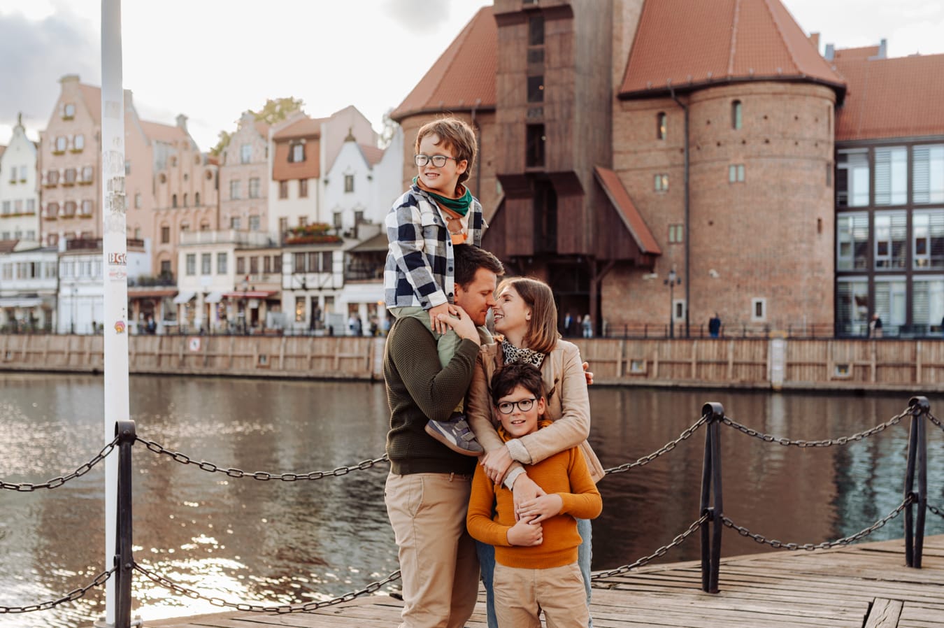 Rodzina z dwoma chłopcami na tle żurawia w Gdańsku podczas miejskiej sesji rodzinnej.