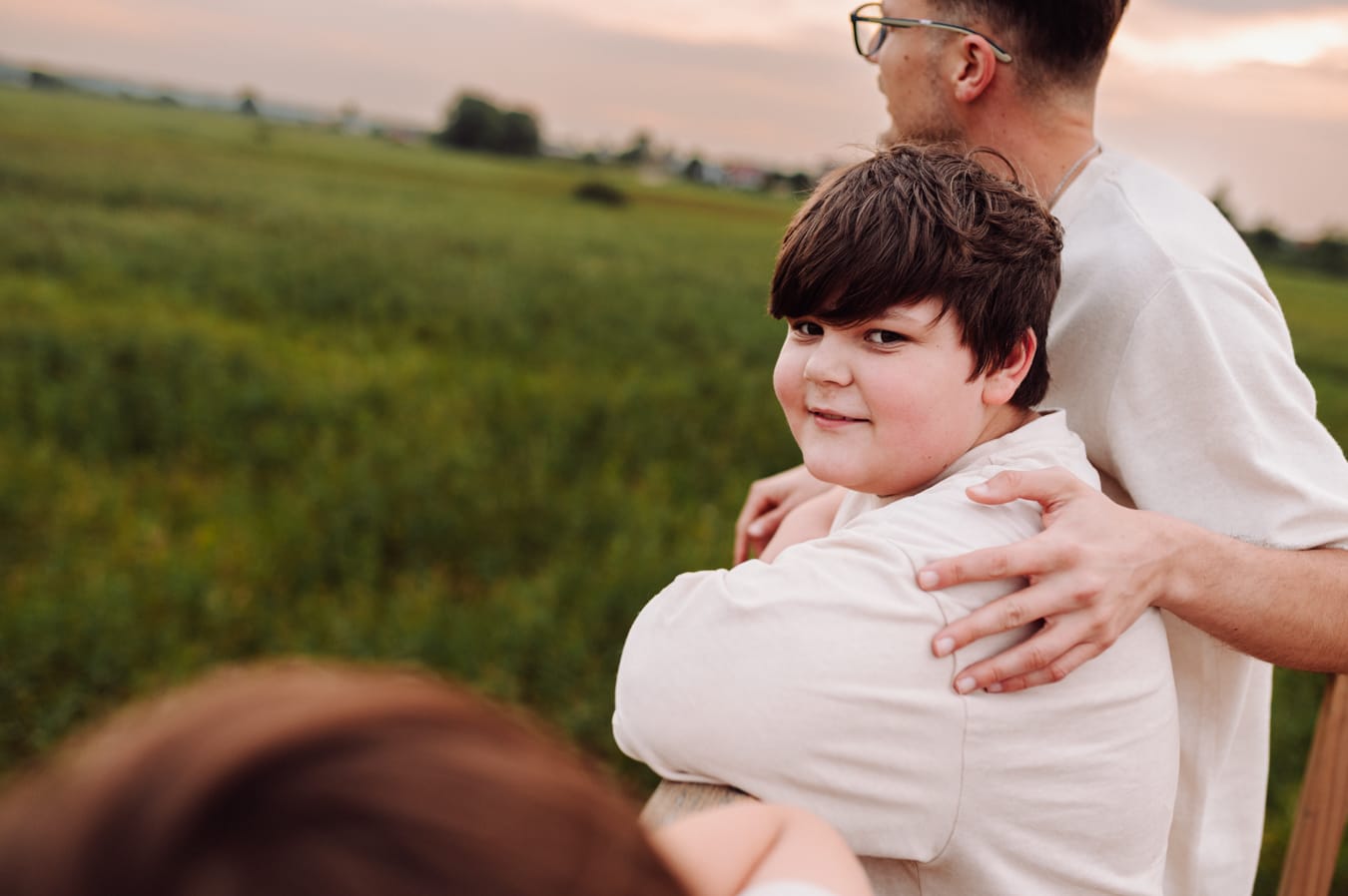 Nastolatek na tle zachodzącego słońca sesja rodzinna