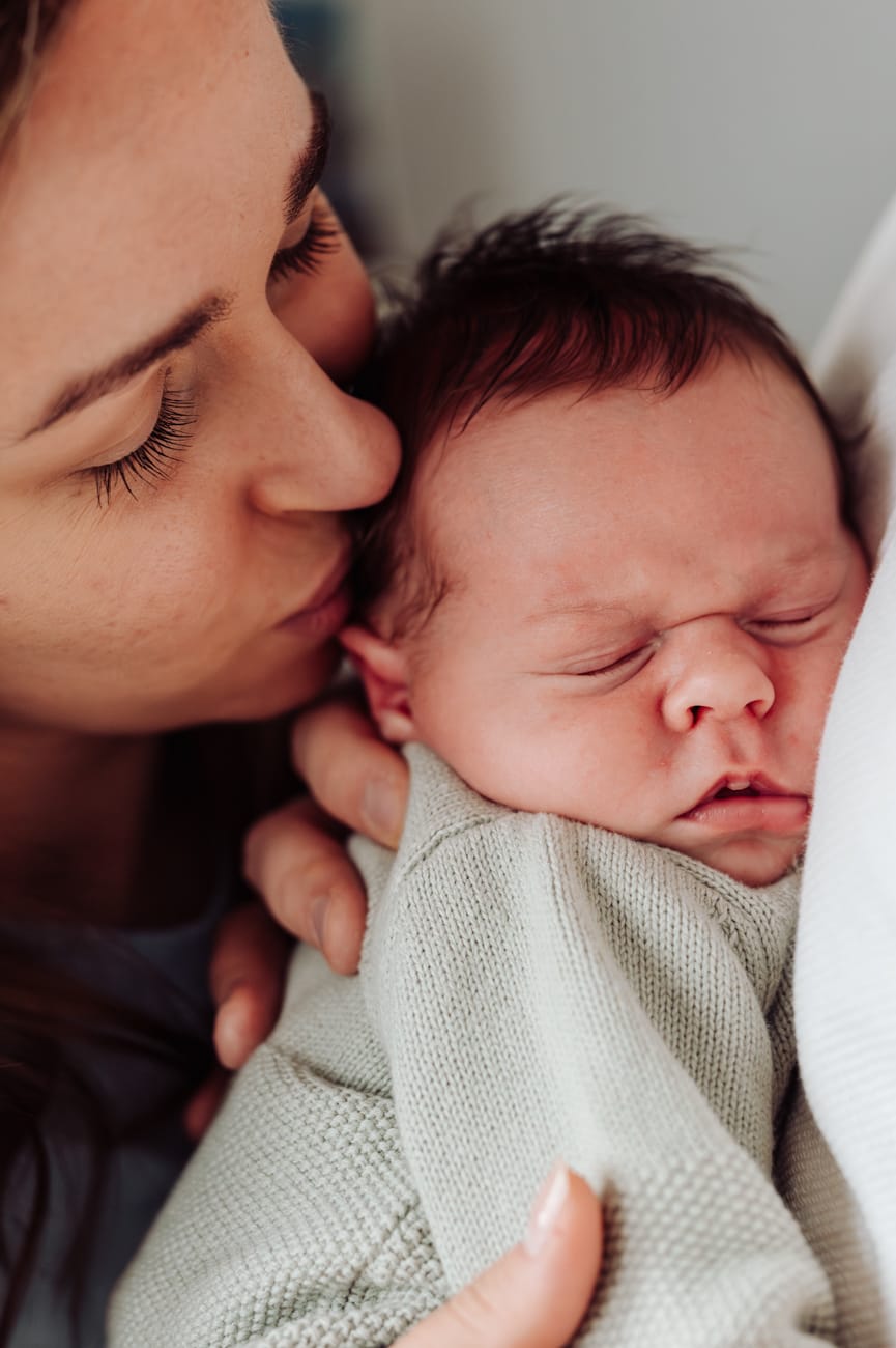 Mama przytula noworodka naturalna sesja lifestyle w domu