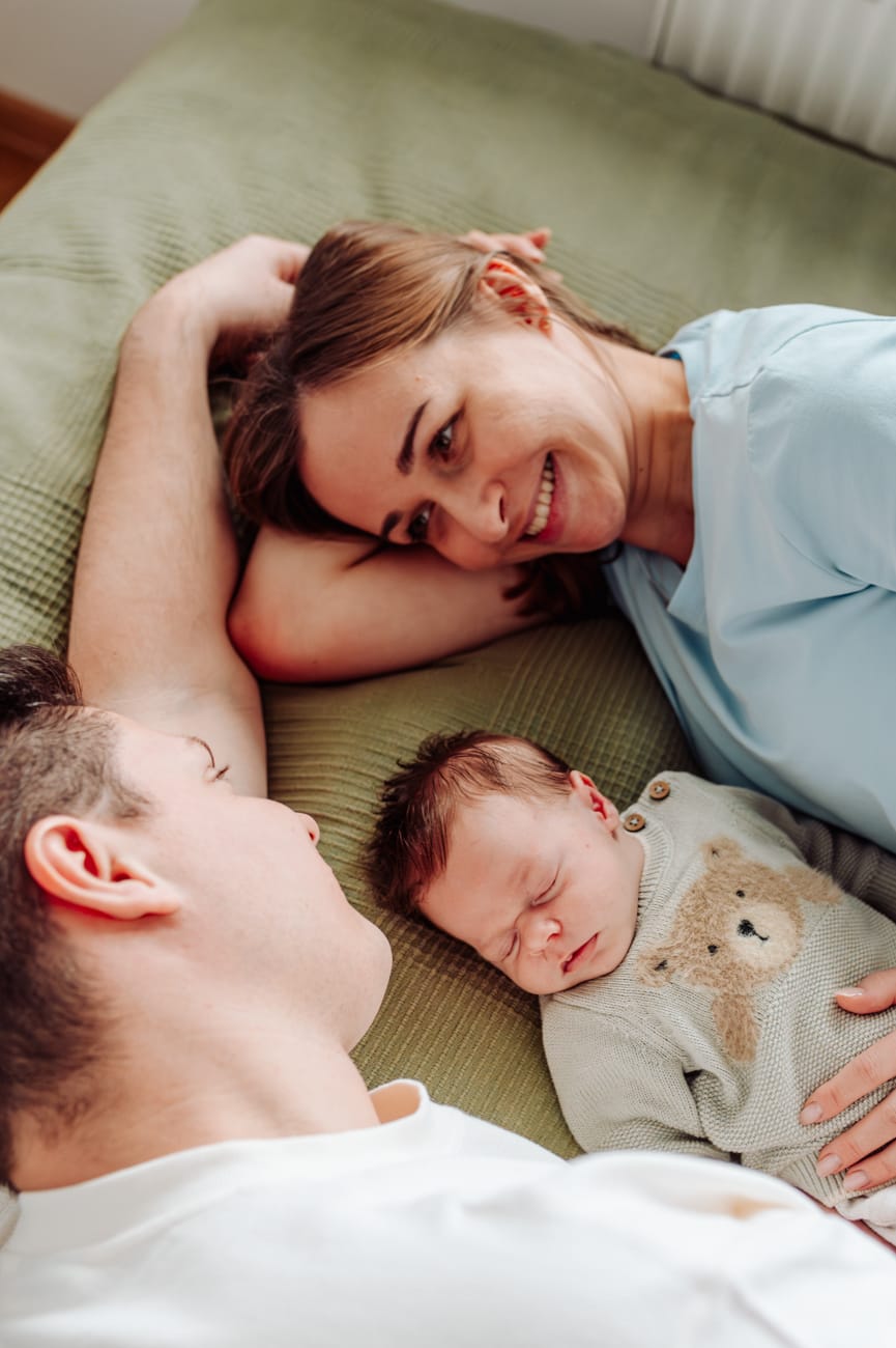 Domowe zdjęcia noworodka lifestyle z rodzicami w jasnej sypialni, Trójmiasto.