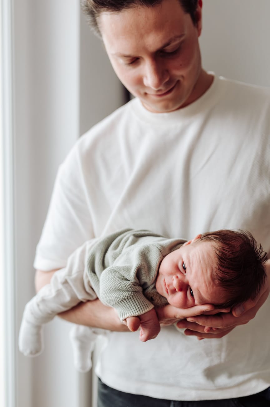 Domowe zdjęcia noworodka lifestyle tata trzyma dziecko na rękach, Gdańsk Gdynia Sopot.