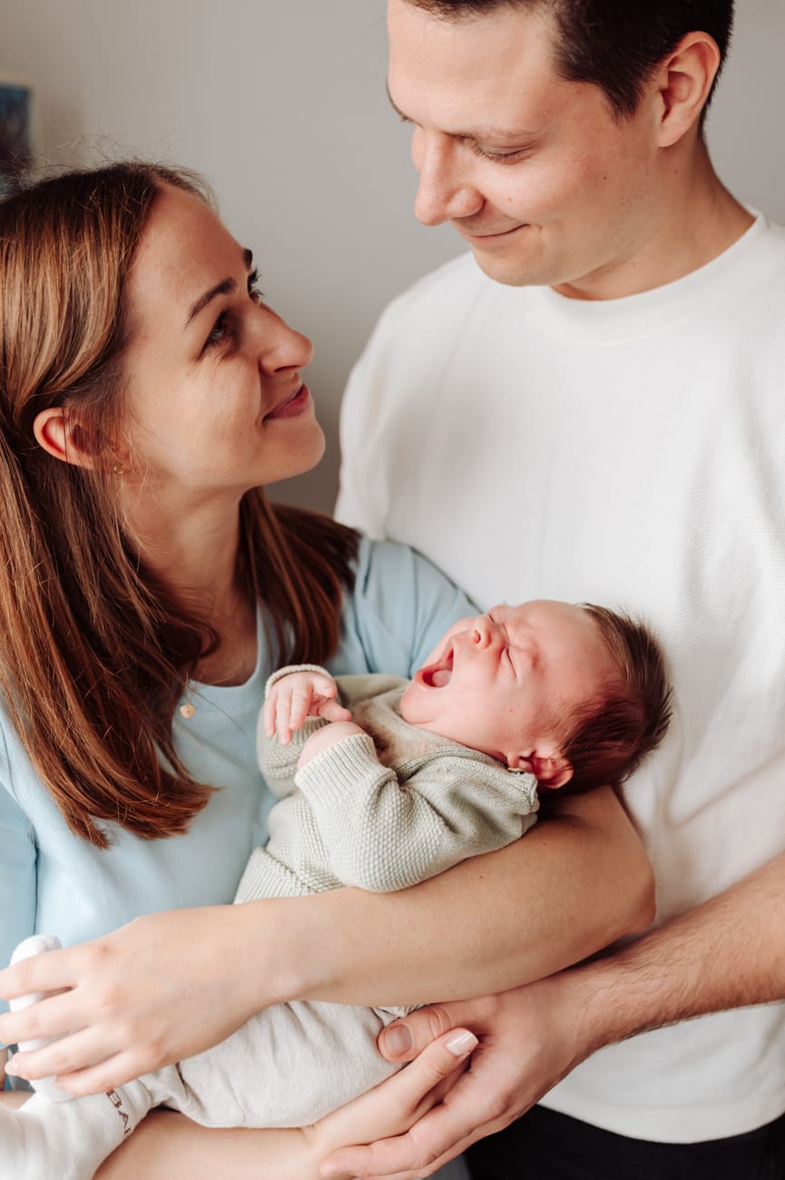 Naturalna sesja noworodkowa lifestyle noworodek śpi w ramionach mamy
