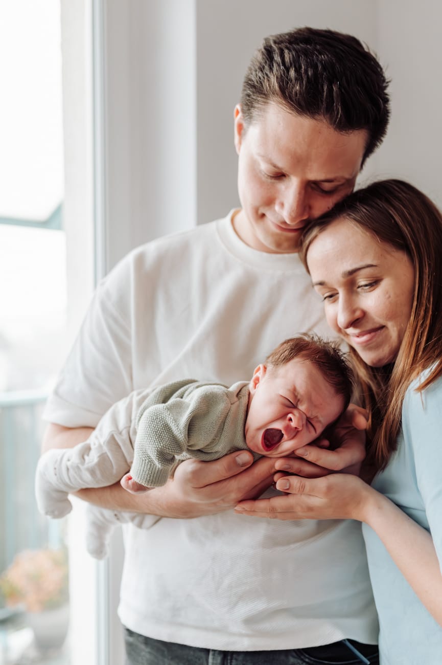 Domowe zdjęcia noworodka lifestyle tata trzyma ziewające dziecko na rękach, Gdańsk Gdynia Sopot.