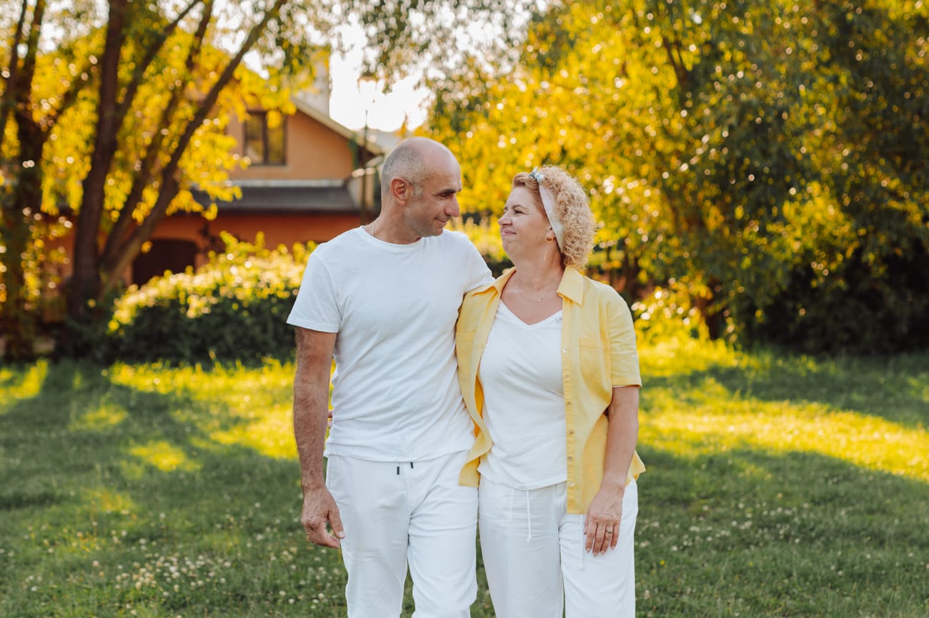Dojrzała para idąca przez łąke o zachodzie słońca Trójmiasto