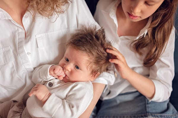 Sesja rodzinna z psem w domu Gdańsk siostra głaszcze niemowlaka
