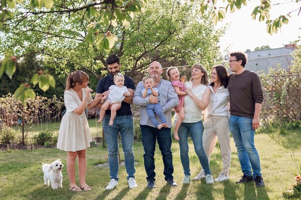 Wspólne zdjęcie dziadków, rodziców i kuzynostwa w pięknym ogrodzie