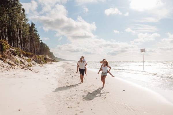 Rodzina biegnie brzegiem morza rodzinna sesja